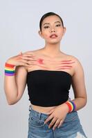 porträtt ung asiatisk kvinna i begrepp lgbq med handledsband på vit bakgrund foto