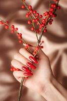 händer av en ung flicka med röd manikyr på naglar foto