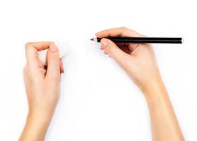 mänsklig händer med penna och radera sudd skrivande något på vit foto