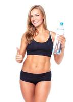 ung atletisk flicka med flaska av vatten på vit foto