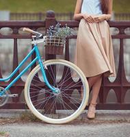 ung vacker, elegant klädd kvinna med cykel foto