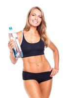 ung atletisk flicka med flaska av vatten på vit foto