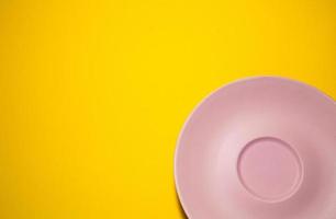 tömma rosa tallrik på en gul bakgrund. minimalism. foto
