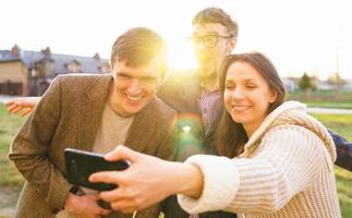 leende vänner framställning selfie utomhus foto