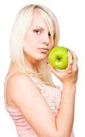skön blond flicka med färsk grön äpple foto