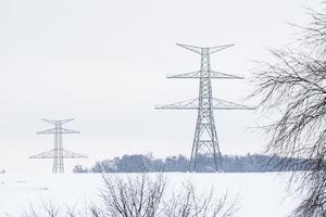 konstruktion av hög Spänning pyloner i vinter. monterad kraft överföring linje stödjer, redo för installation. foto