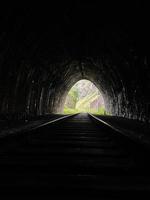 ljus på de slutet av de tunnel, utgång från de mörk järnväg tunnel foto