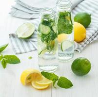 infuserad vatten med citrus- och mynta i glas flaskor foto