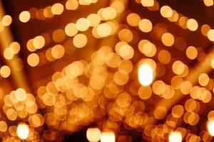 abstrakt gyllene suddig jul lampor bokeh bakgrund. skön lysande skimrar, blinkning jul träd lampor blinkande. vinter- högtider begrepp. defocused lampor med bokeh gnistra mönster. foto