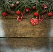 jul gräns med gran träd grenar, kottar, jul dekorationer och godis käppar foto