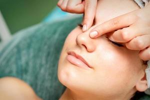 ung kvinna få ansiktsbehandling massage foto