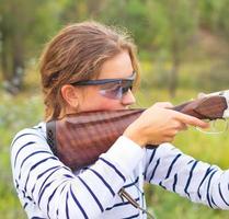 en ung flicka med en pistol för fälla skytte foto