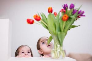 två systrar med vår tulpan bukett. Semester dekor med blommor färgrik tulpaner. foto