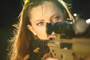 flicka med en pistol för fälla skytte siktar på en mål foto
