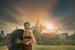 skön asiatisk kvinna bär thai tradition kostym stående mot gammal tempel i ayutthaya värld arv webbplats av unesco central av thailand foto