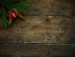 jul träd grenar med koner och jul dekorationer på trä- textur redo för din design foto