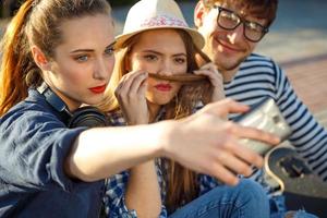 leende vänner framställning selfie utomhus foto