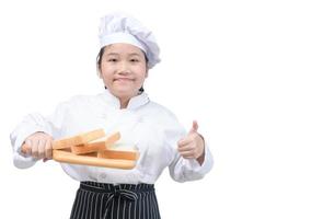 porträtt av en professionell flicka kock visa bröd på trä tallrik isolerat foto