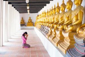 asiatisk kvinna till betala respekt till buddha staty i thailand. foto