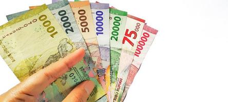 en man innehav nytt utfärdad indonesiska sedlar. rupiah valuta begrepp isolerat på vit bakgrund. negativ Plats foto