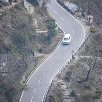 ovanifrån från luften av trafikfordon som kör på bergsvägar vid nainital, uttarakhand, Indien, utsikt från toppen av berget för förflyttning av trafikfordon foto