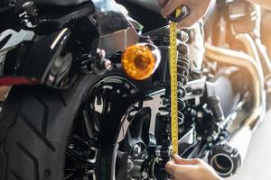 mekaniker använder sig av tejp mäta uppsättning upp suspension svikta kompression och studsa tillbaka på motorcykel på garage, reparera och underhåll motorcykel begrepp .selektiv fokus foto