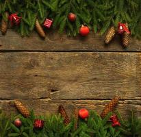 jul gräns med gran träd grenar, koner och jul dekorationer på rustik trä- styrelser foto