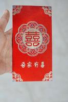 hand innehav röd kuvert gåva kinesisk ny år foto