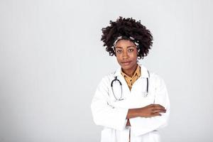 medicin, yrke och sjukvård begrepp - Lycklig leende afrikansk amerikan kvinna läkare i vit täcka med stetoskop över bakgrund foto