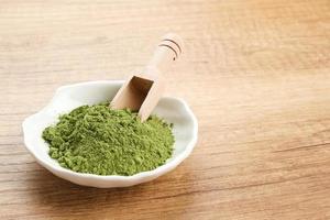 grön matcha pulver i vit skål, mat ingrediens foto