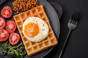 utsökt hjärtlig frukost bestående av en friterad ägg, belgisk våffla foto