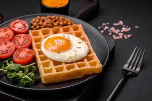 utsökt hjärtlig frukost bestående av en friterad ägg, belgisk våffla foto