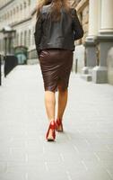 kvinna bär elegant kjol och röd hög häl skor i gammal stad foto