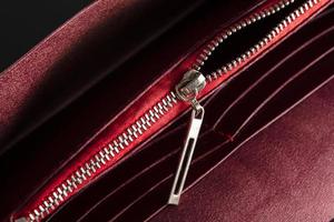 ett öppen dragkedja på en röd läder Artikel eller plånbok. foto