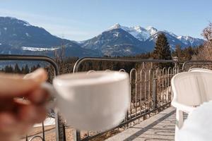 naturskön se av snö täckt berg med person innehav kaffe kopp foto