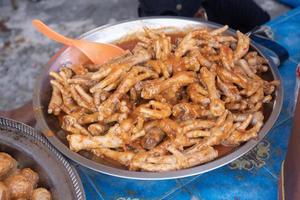 Wokad kyckling ben med chili sås, i indonesiska den är kallad Wokad kyckling fötter. eras på en pott för försäljning på kulinariska festivaler foto