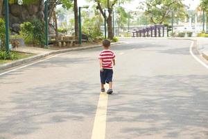 en pojke löpning på de gata i de parkera foto