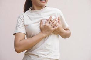 asiatisk kvinna tajt bröst, kan inte andas foto