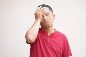asiatisk man har en huvudvärk påfrestning från arbete. foto