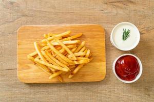 pommes frites med gräddfil och ketchup foto