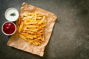 pommes frites med gräddfil och ketchup foto