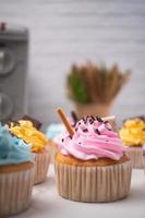 läckra hemgjorda cupcakes med färgglad grädde och toppning med godis och chokladkakor. hemlagad höstlovsdessert foto