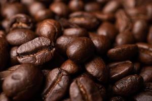 stänga upp av grupp svart kaffe bönor. stark svart espresso, grunder av kaffe bakgrund, textur foto