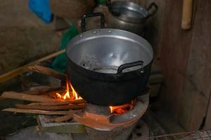 pott på de brasa de botten av de pott har svart sot medan matlagning. de brasa brand är fortfarande Begagnade i lantlig kök i de norr och nordost av thailand. mjuk och selektiv fokus. foto