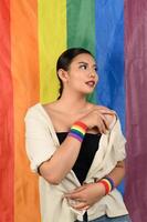 Söt kvinna lgbq utgör med flerfärgad flagga foto