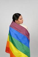 Söt kvinna lgbq utgör med flerfärgad flagga foto