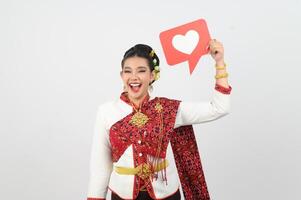 ung skön kvinna i thai lanna kostym med kort kort i hjärta symbol foto