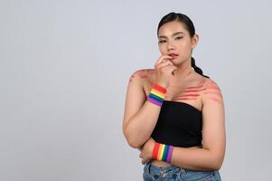 porträtt ung asiatisk kvinna i begrepp lgbq med handledsband på vit bakgrund foto