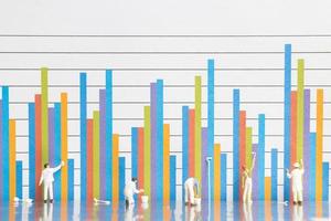 miniatyrarbetare målar affärsdiagram på en vit bakgrund, affärstillväxtkoncept foto