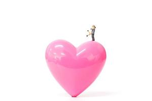 miniatyrpar med rosa hjärta på vit bakgrund, alla hjärtans dagskoncept foto